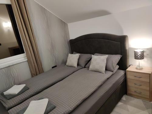 Cette chambre comprend un grand lit et une table de nuit. dans l'établissement Apartments Battistutti Zagreb, à Zagreb