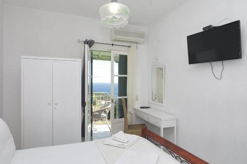 a bedroom with a bed and a tv on the wall at Pelagos in Stafylos
