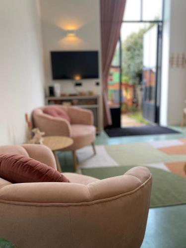a living room with chairs and a table and a tv at De Kerck - bijzonder overnachten in Middelburg