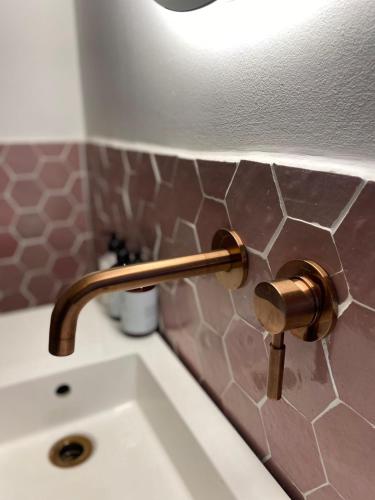 a bathroom sink with a brass faucet on a counter at De Kerck - bijzonder overnachten in Middelburg