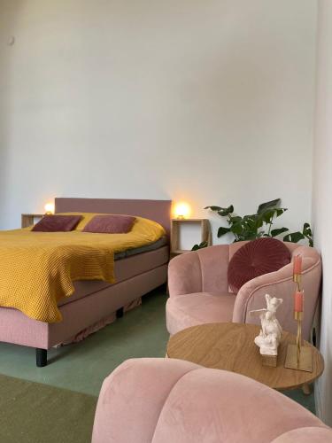 a bedroom with a bed and a bed and a couch at De Kerck - bijzonder overnachten in Middelburg