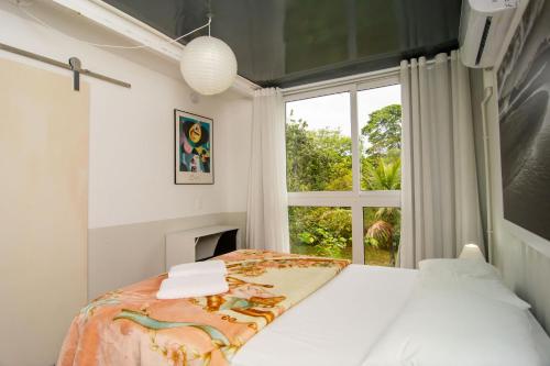 1 dormitorio con cama y ventana en Casa Container Incrível no Campeche, 2 hóspedes SUL91 en Florianópolis