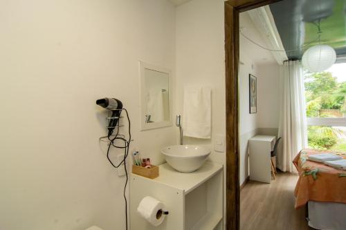 Baño blanco con lavabo y espejo en Casa Container Incrível no Campeche, 2 hóspedes SUL91, en Florianópolis