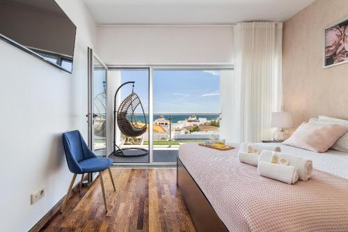 a bedroom with a bed and a chair and a window at Praia Mar by OCvillas in Albufeira