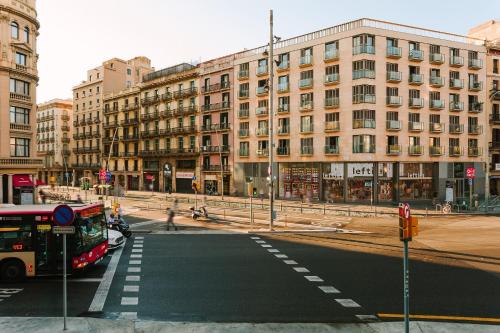 a bus is stopped at an intersection in a city at Sonder Casa Luz in Barcelona