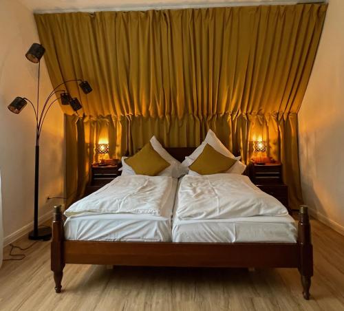 łóżko w pokoju z żółtymi zasłonami w obiekcie Hotel Schloss Diepenbrock w mieście Bocholt