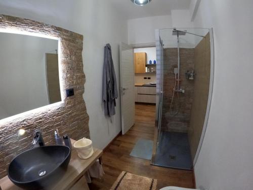 a bathroom with a sink and a glass shower at La Dimora del Piccolo Buddha in Rapallo