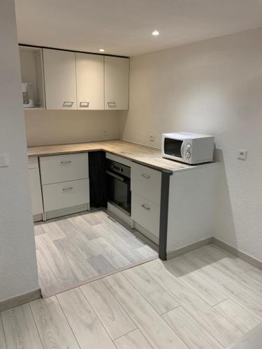 une cuisine avec un comptoir avec un micro-ondes dessus dans l'établissement Appartement 1er Etage 42m2 hyper centre ville / parking gratuit, à Riom