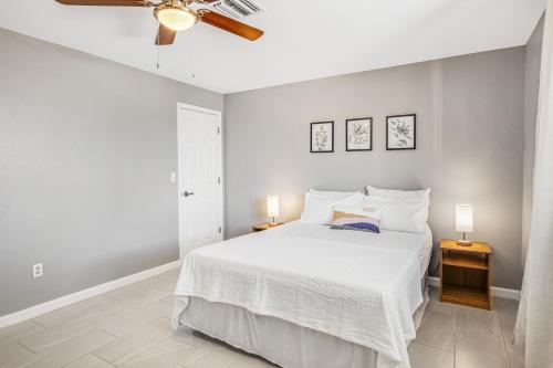 a white bedroom with a bed and a ceiling fan at Cathay Place in Tucson