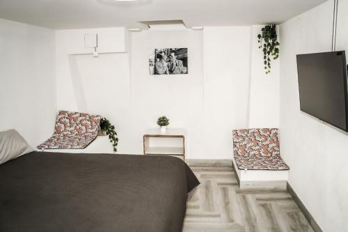 a bedroom with a bed and two chairs at Tofi in Madrid