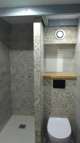 La salle de bains est pourvue de toilettes et d'une horloge murale. dans l'établissement Chezmaryline, à Vielle-Aure