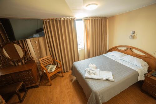 1 dormitorio con 1 cama con 2 toallas en Hostal Premier Arequipa, en Arequipa