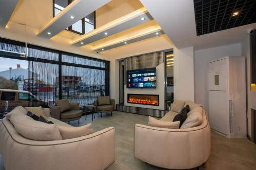 a living room with two couches and a fireplace at Intercity Airport Hotel in Arnavutköy