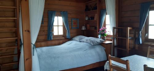 1 dormitorio con 1 cama en una cabaña de madera en Kiskemence Vendégház Szatta, en Szatta
