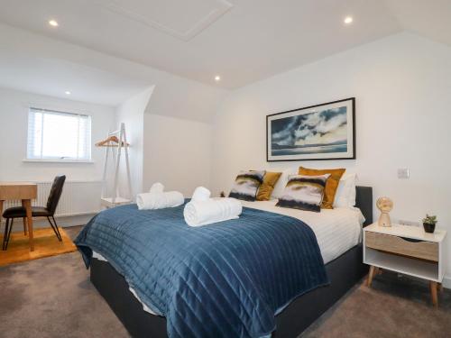 a bedroom with a large bed with a blue blanket at Little Reef in Newquay