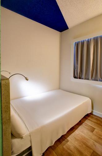 a bed in a room with a blue ceiling at ibis budget Tambore in Barueri