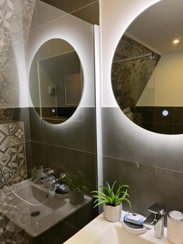 ein Bad mit einem Waschbecken und einem Spiegel in der Unterkunft Klek 77 Luxury Chalets near Jahorina 