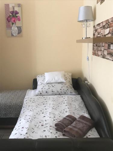 a bed with two pillows on it in a room at Melinda Apartman in Kaposvár