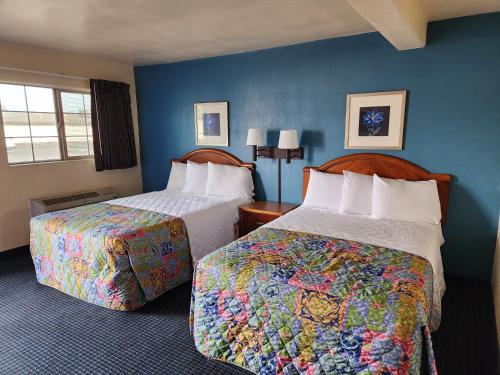 a hotel room with two beds and blue walls at Chandler Inn in Chandler