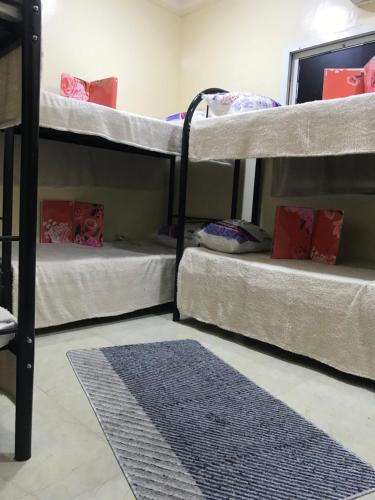 three bunk beds in a room with a rug at Guest House in Dubai