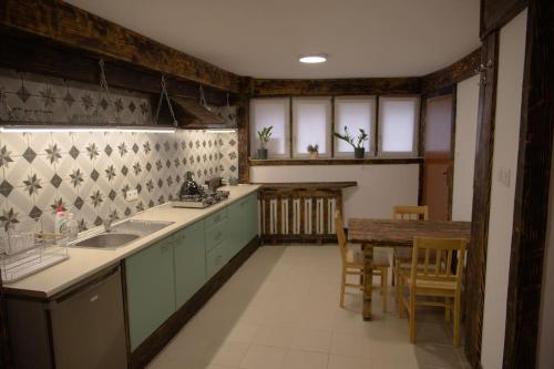uma cozinha com um lavatório e uma mesa com cadeiras em Kongres Czarownic em Zagnańsk