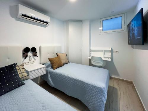 een kleine slaapkamer met een bed en een badkamer bij El Dorado 114 luxury with full air-conditioning in Playa de las Americas