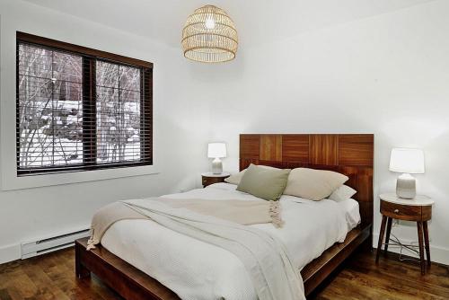 Un dormitorio blanco con una cama grande y una ventana en Chalets Alpins- 27 Chemin des Skieurs, en Stoneham
