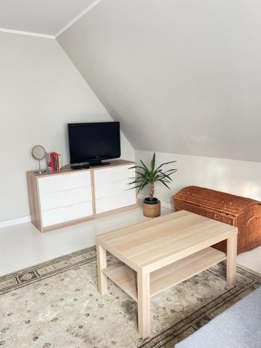 a living room with a coffee table and a tv at Morski Zakątek Kołobrzeg - Dom z ogrodem na wyłączność in Kołobrzeg