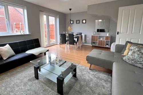 uma sala de estar com um sofá e uma mesa em Modern 3BR House For Contractors em Stockingford