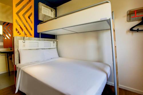 a bed in a small room with a bunk bed at ibis budget Tambore in Barueri