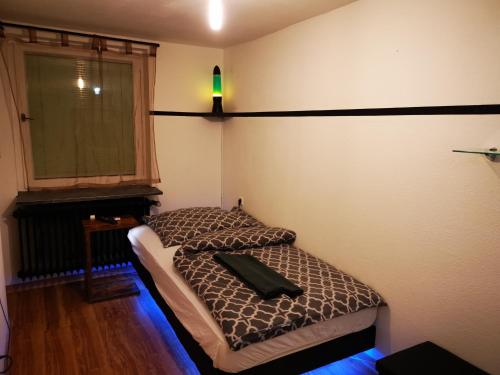 a small bed in a room with a window at Gut und günstig !!! in Weingarten