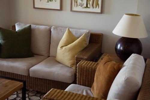 a living room with a couch and a lamp at Vineyard Apartment in Tutukaka