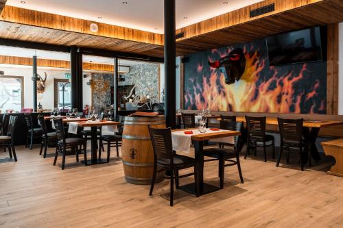 a restaurant with tables and chairs and a barrel wall at Melchtal Resort Apart Hotel in Melchtal