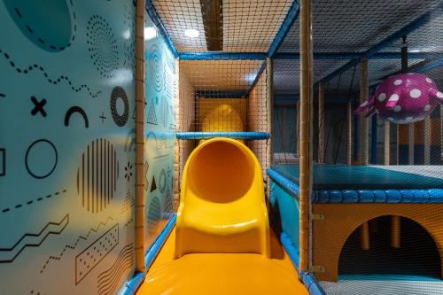 a play room with a slide and a climbing wall at Melchtal Resort Apart Hotel in Melchtal