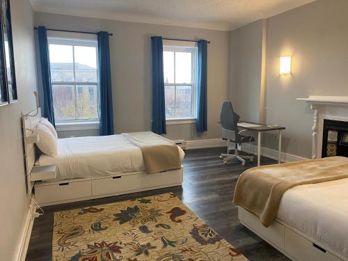 a bedroom with two beds and a desk and a chair at Hotel Bedford in Goderich