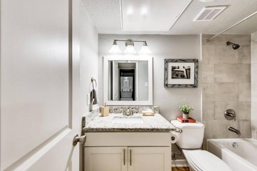 a bathroom with a sink and a toilet and a tub at The Classic • Near Knox Henderson in Dallas