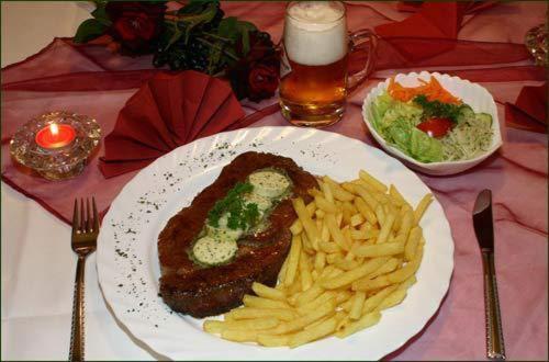 a plate of food with meat and fries on a table at Hotel Deutsches Haus und Restaurant Olympia in Magdeburg