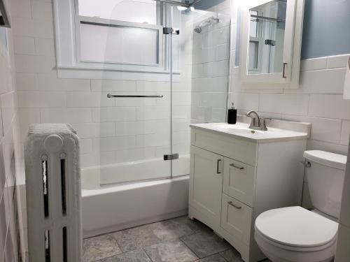 La salle de bains est pourvue de toilettes, d'un lavabo et d'une douche. dans l'établissement The Uptown Oasis, à Minneapolis