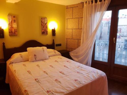een slaapkamer met een bed, een raam en een deur bij Apartamento Cervantes - Piedad Fernandez Fernandez Gestión de Inmuebles SL in Béjar