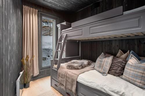 ein Schlafzimmer mit einem Etagenbett mit einer Leiter in der Unterkunft Kikut Alpine Lodge 9103 in Geilo