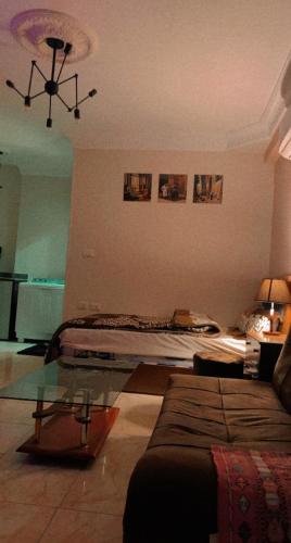 a living room with a bed and a glass table at Comfy Apartment with private yard in 6 October city Cairo in 6th Of October