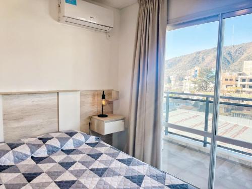 a bedroom with a bed and a window with a view at Torre Leonardo Carlos Paz in Villa Carlos Paz