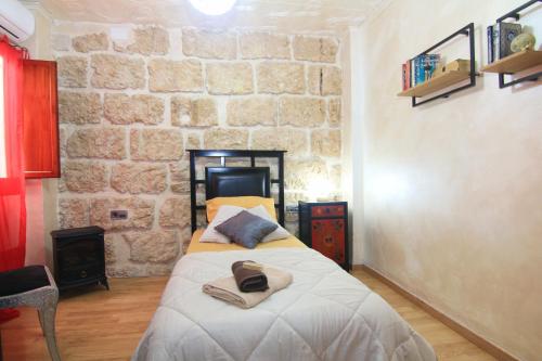 um quarto com uma cama e uma parede de pedra em Casa Marrón Boutique Home em Benissa