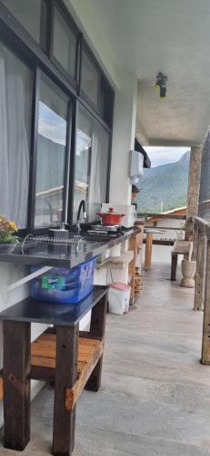 uma cozinha com bancada e algumas janelas em Suite Ilhabela - com varanda e vista panorâmica em Ilhabela