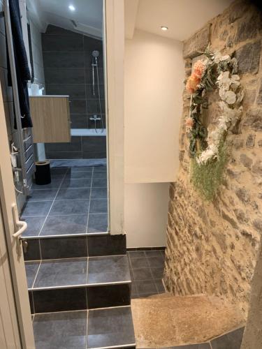 een badkamer met een inloopdouche en een stenen muur bij La Magnanerie in Mialet