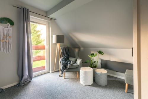 a living room with a chair and a window at Zacisze Pod Śmielcem in Jelenia Góra-Jagniątków