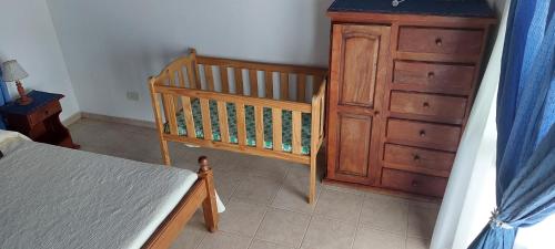 - une chambre avec un lit bébé et une commode en bois dans l'établissement Ayres Serranos, à Merlo