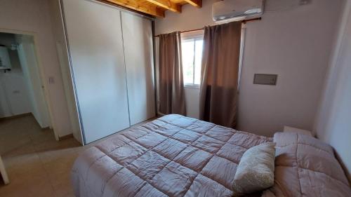 Un dormitorio con una cama grande y una ventana en Los Coirones en Maipú
