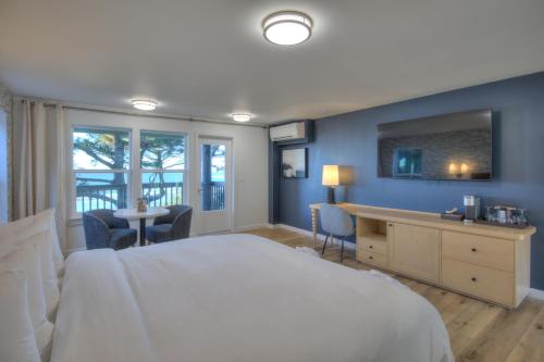 um quarto com uma grande cama branca e uma secretária em Ocean Crest Resort em Moclips
