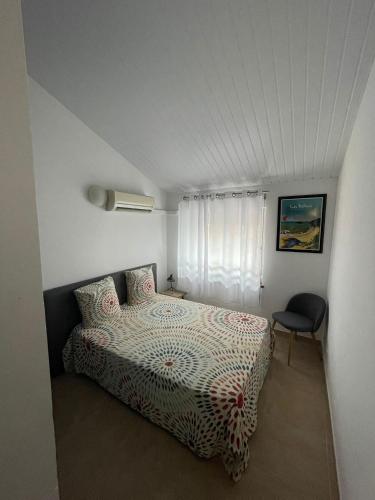 a bedroom with a bed and a chair in it at NANA COCOONING- C42- Vue Panoramique - Appartement Cosy et Lumineux- Cuisine équipée- CLIM-Terrasse in Cayenne